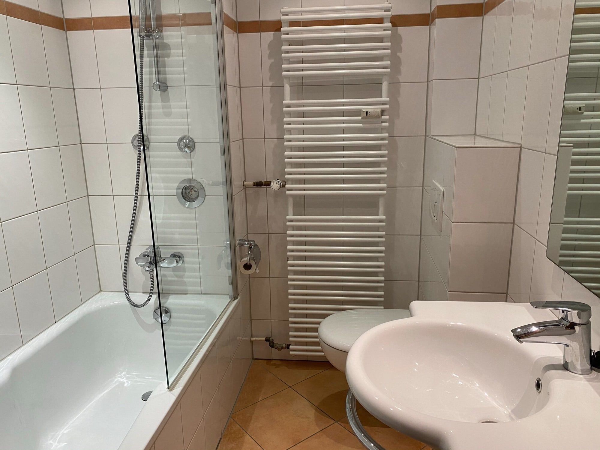 Sauberes Badezimmer mit Badewanne, Waschbecken und Handtuchheizung